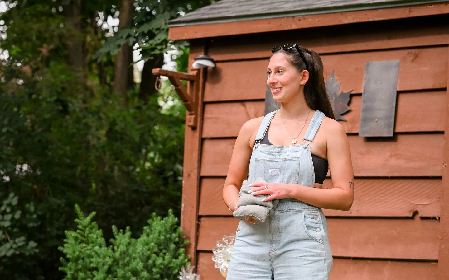 A woman playing cornhole at a backyard gathering