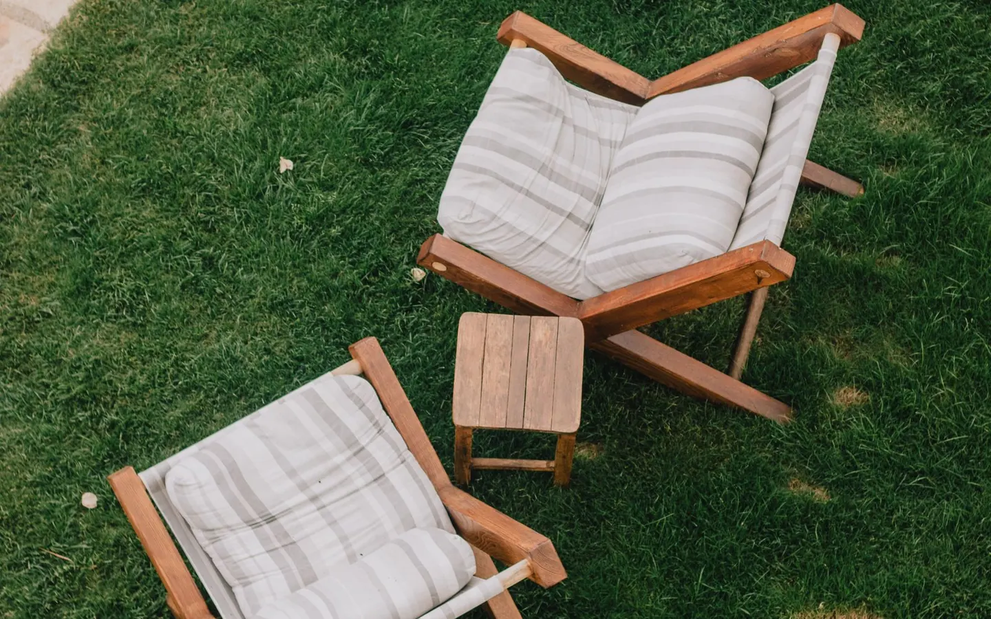 Overhead view of wooden chairs and a table on a small patch of green lawn