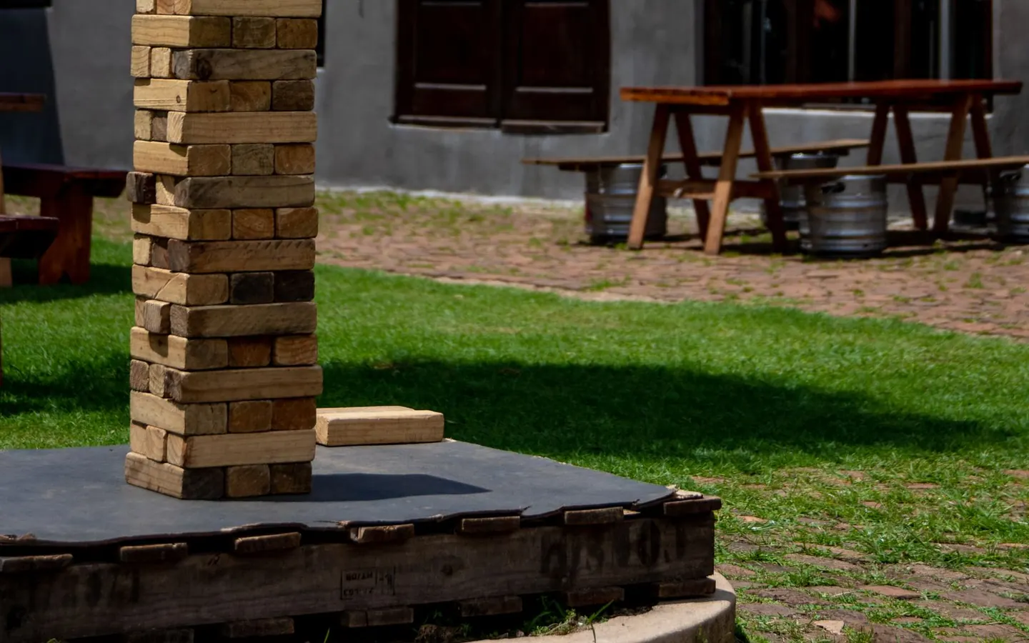 A large wooden block-stacking tower set up outdoors in a backyard