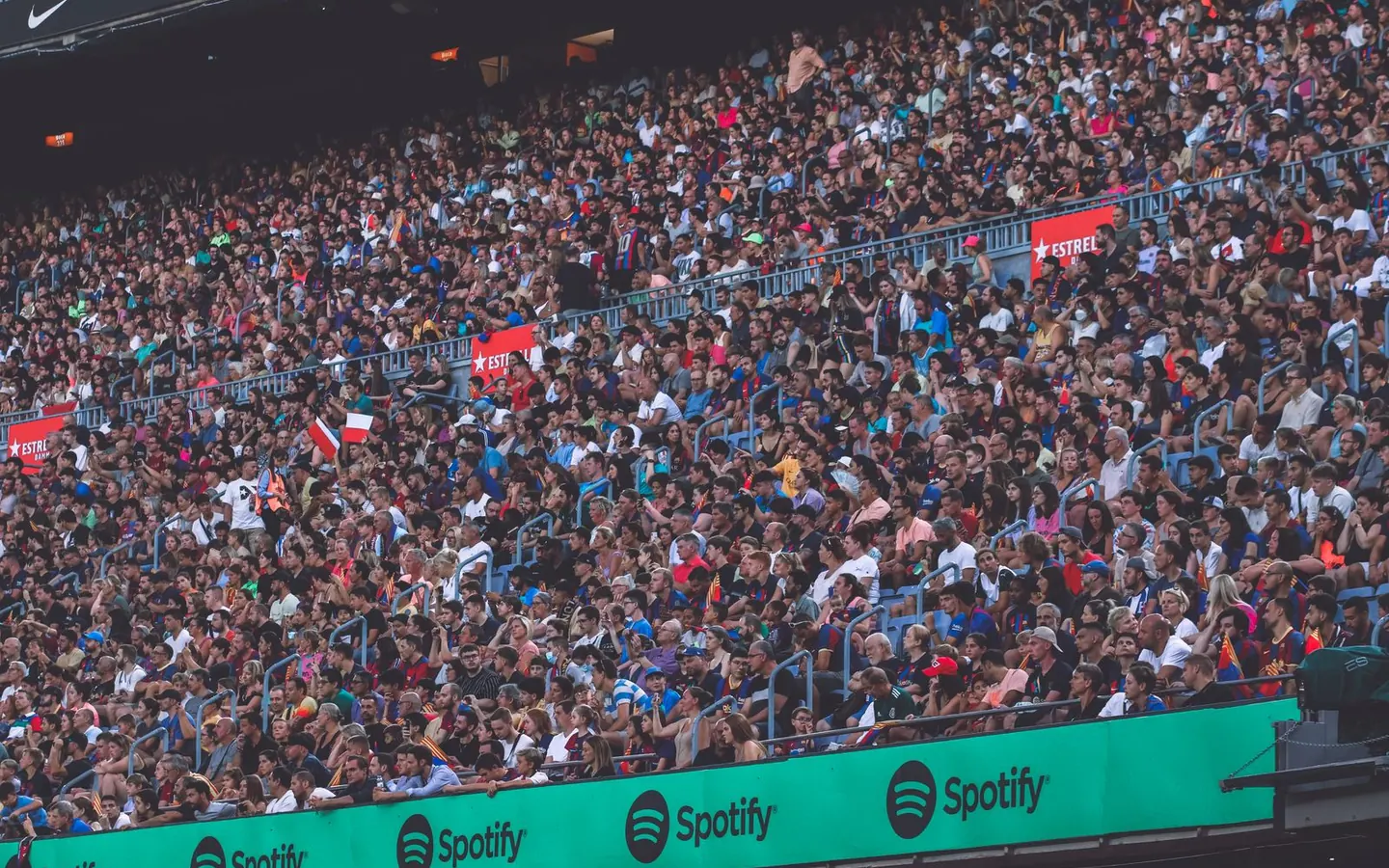 A packed stadium of spectators cheering at a sporting event